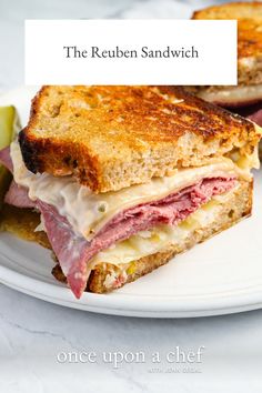 the reuben sandwich is cut in half on a plate with pickle slices and an apple