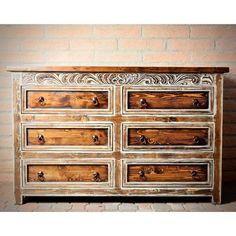 an old dresser with many drawers and knobs on the doors is shown in front of a brick wall