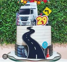 a birthday cake with a truck on it and decorations around the top that says 29