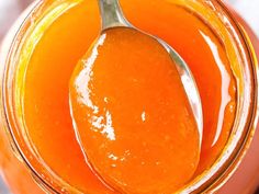 a spoon in a jar filled with orange liquid