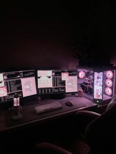 three computer monitors sitting next to each other on top of a desk in the dark