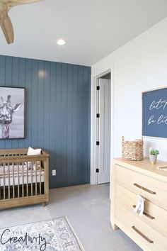 a baby's room with blue painted walls and white crib in the foreground