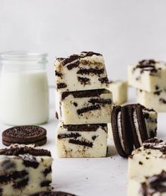 oreo cookies and cream cheesecakes are stacked on top of each other next to a glass of milk