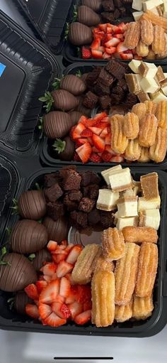 three trays filled with different types of desserts and strawberries on top of each other