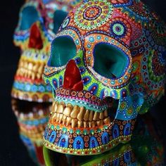 two brightly colored skulls sitting next to each other