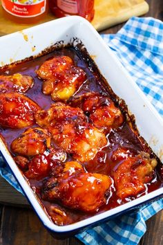 a casserole dish with meat and sauce in it on a blue checkered cloth