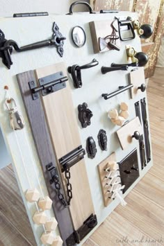 an assortment of door handles and knobs are displayed on a white board with wood planks