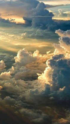 the sky is filled with lots of white and grey clouds, as seen from an airplane window