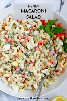 a white bowl filled with macaroni salad on top of a marble countertop