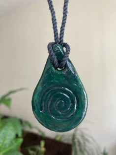 a green stone hanging from a rope