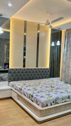 a bedroom with a bed, mirror and lights on the wall next to it's headboard