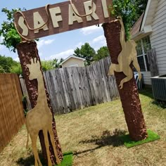 a wooden sign that says safari with two giraffes on it