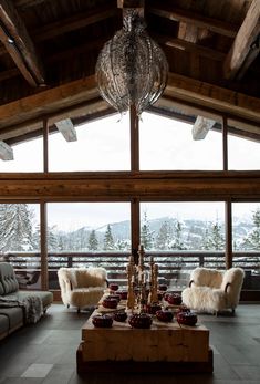 a living room filled with lots of furniture and a chandelier hanging from the ceiling