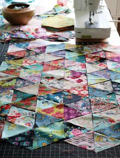 a table topped with lots of different types of quilts