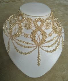 a white mannequin with gold beads on it