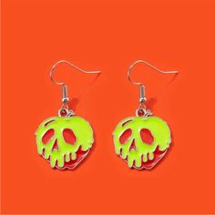 two pairs of neon green and red earrings on an orange background