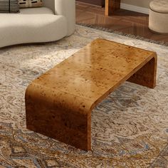 a coffee table sitting on top of a rug in a living room next to a couch