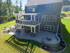 an aerial view of a large house in the middle of a green yard with stairs leading up to it