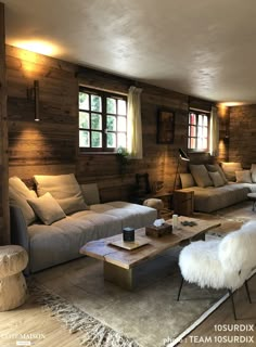 a living room filled with furniture and wooden walls