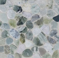 a close up view of some rocks on the ground with green and white colors in it