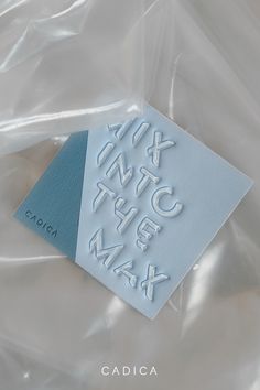 a close up of a piece of paper with letters on it and a tag in the middle