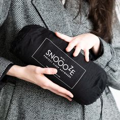 a woman is holding a black bag with the name snooze on it