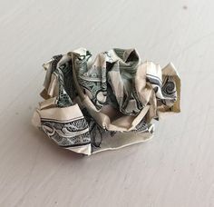 an origami ball made out of one dollar bill on a table top with white background