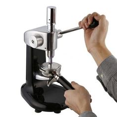 a person is using a coffee maker to make espresso in front of a white background