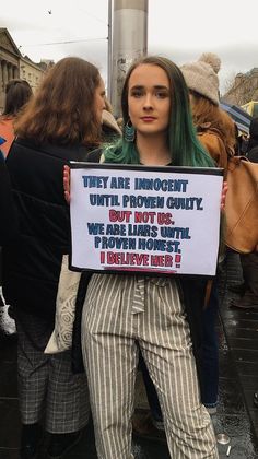 a woman holding up a sign that reads they are innocent until proven guilty but not useful