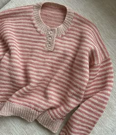 a red and white striped sweater sitting on top of a couch