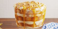 a dessert with bananas and caramel drizzled on top, sitting on a wooden table