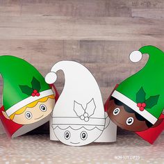 three paper christmas hats sitting on top of each other next to an egg box with the faces of two children