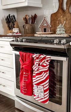 the oven door is open and there are christmas stockings hanging from it's handle