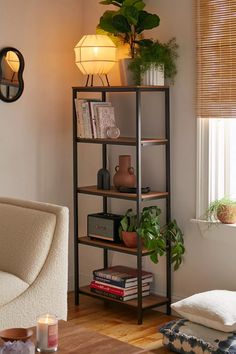 a living room filled with furniture and a potted plant on top of a shelf