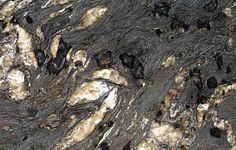 black and white marble with brown streaks on it's surface, as well as other things in the background