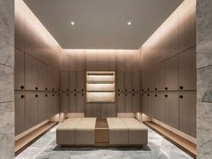 an empty room with wooden cabinets and benches in it, along with marble flooring