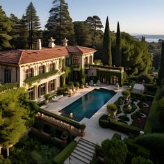 an aerial view of a large house with a pool in the middle and trees surrounding it