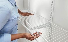 a man is holding the bottom shelf of a refrigerator