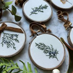 embroidered christmas ornaments are displayed on a table