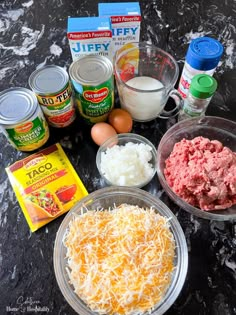 an assortment of ingredients are displayed on a counter top, including eggs, cheese and ground beef