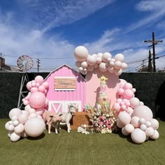 a pink barn decorated with balloons and flowers