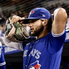 a baseball player adjusts his catcher's mitt