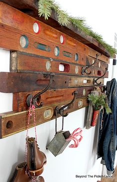 a wooden coat rack with many different items hanging from it's sides and on the wall