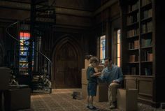 a man sitting next to a little boy in a library