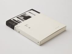 an open book sitting on top of a white table next to a black and white photo