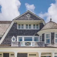 a large gray house with white trim and windows