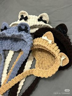 three crocheted hats with black bows on them are laying on a gray surface