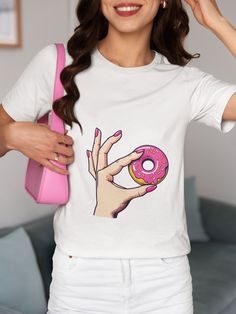 Indulge in a sweet treat with our Retro Pink Donut T-Shirt! This unique graphic tee features a stylish pop art design of a hand with perfectly manicured pink nails holding a delicious donut topped with vibrant sprinkles. Made from soft, breathable cotton, this unisex t-shirt is perfect for casual outings, food lovers, or as a fun gift for friends and family. We utilize the authentic Bella Canvas 3001 brand, renowned for its UNISEX design, making it one of the most sought-after shirts in the mark Pink Donuts, Funny Graphic Tees, Unisex Design, Solid Black, Food Lover, Cotton Shirt, Length Sleeve, Gift For Lover, Pop Art