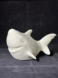 a white ceramic shark with its mouth open