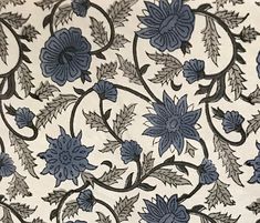 blue flowers and leaves on white fabric with black trim around the edges in an intricate pattern